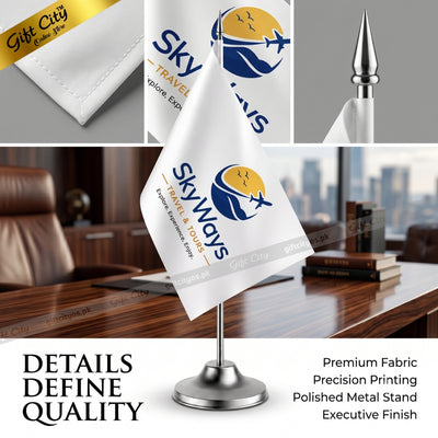 A white table flag on a polished silver metal stand, printed with the 'Skyways Travel & Tour' logo. The image is a composite showing the flag in an office setting, close-up details of the fabric, and a gold gift box, with text highlighting premium fabric and precision printing.