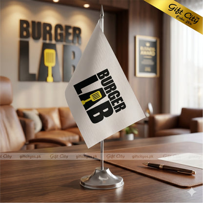 Tabletop flag with 'Burger Lab' design on a desk in a restaurant setting.